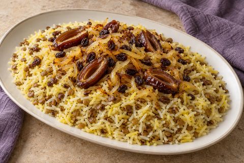 Lentil rice topped with golden onions, dark raisins and halved pitted dates; AI illustration.