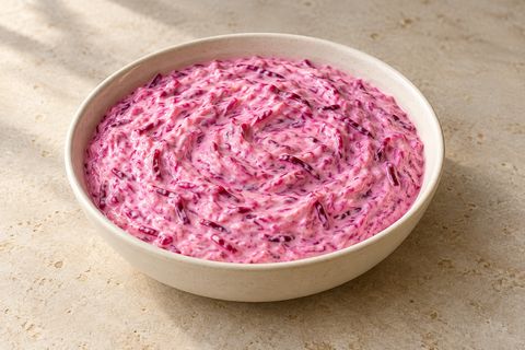 Pink yogurt dip with fine grated beet strands and no garnish; AI illustration.