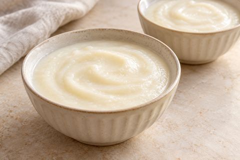 Small bowls of smooth white rice-flour and milk pudding without toppings; AI illustration.