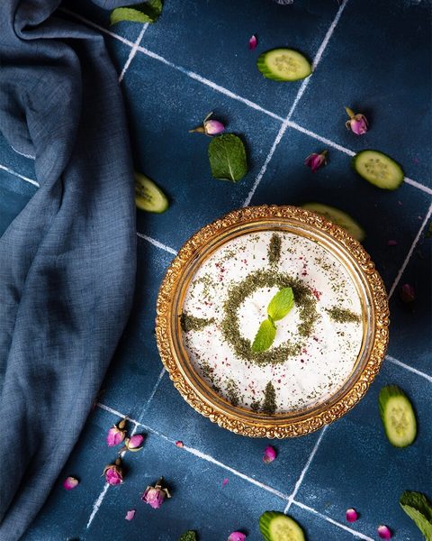 Yogurt-and-cucumber side topped with mint and a decorative flower-petal garnish